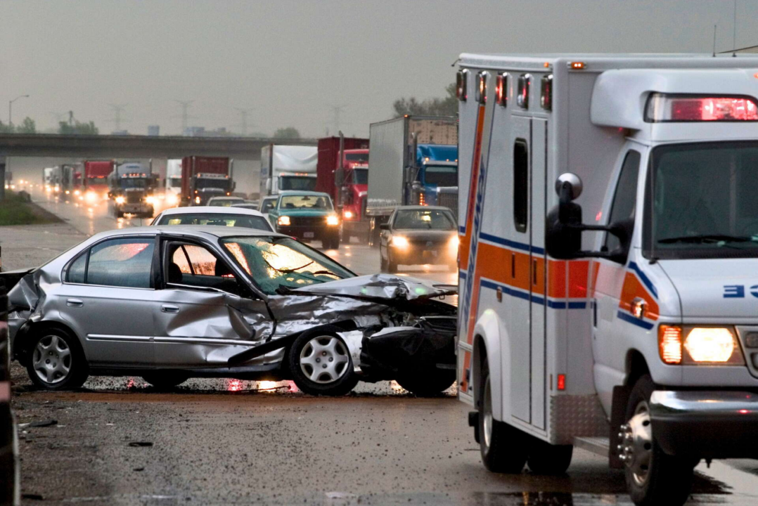 A wrecked car with an ambulance in the foreground, someone's first car accident
